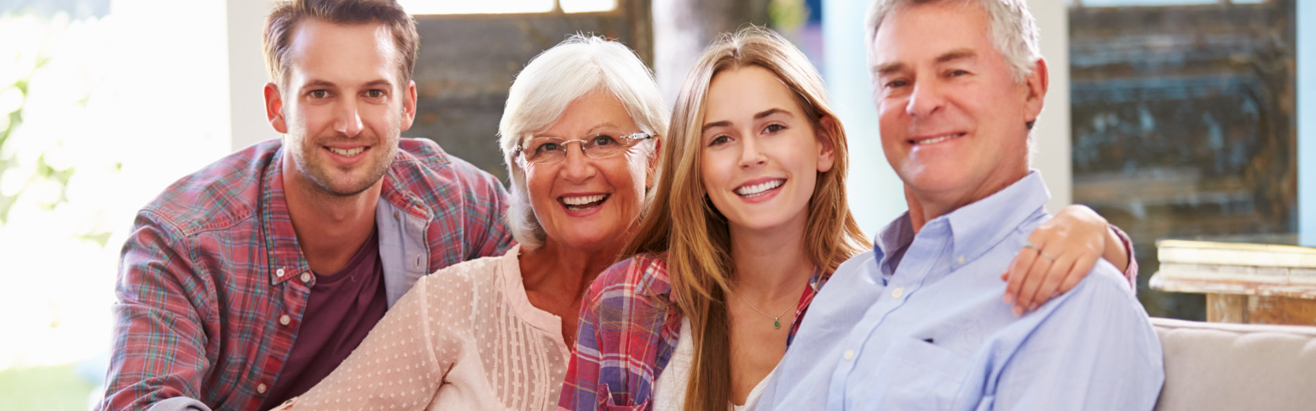 Family With Adult Children Relaxing On Sofa At Home Together