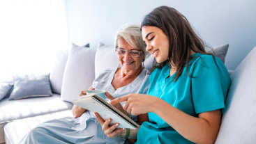 woman and senior looking in a book