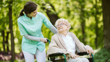 woman pushing the senior in wheelchair