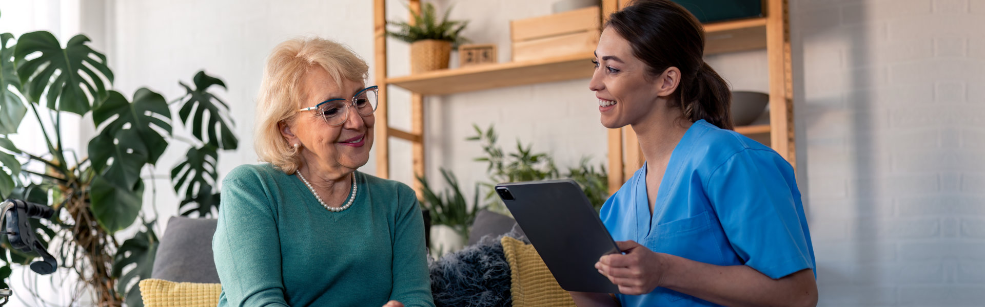 woman with senior holding a tablet